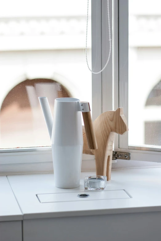 white wooden figures are placed next to a window