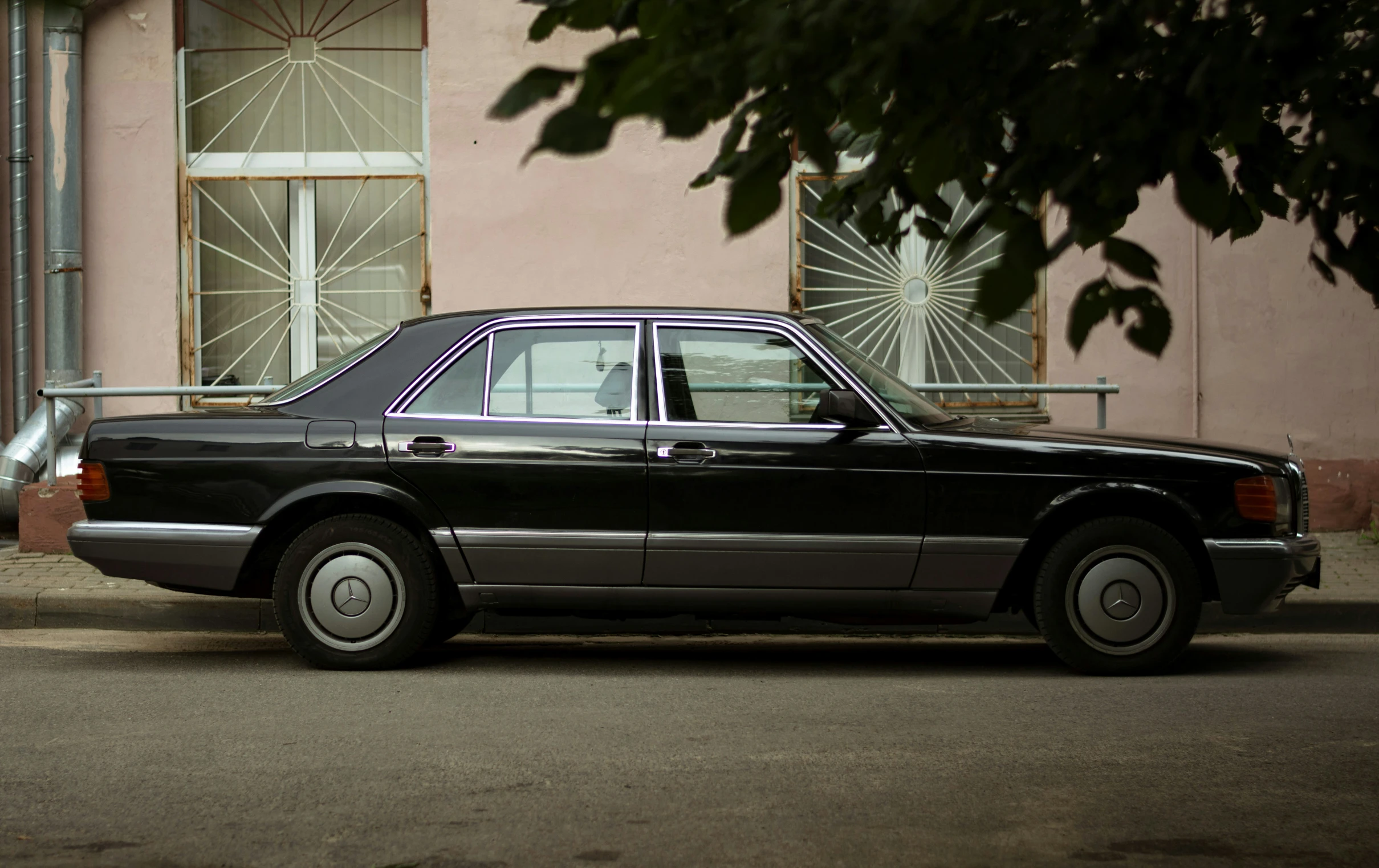 an old mercedes parked on a sidewalk with no one inside