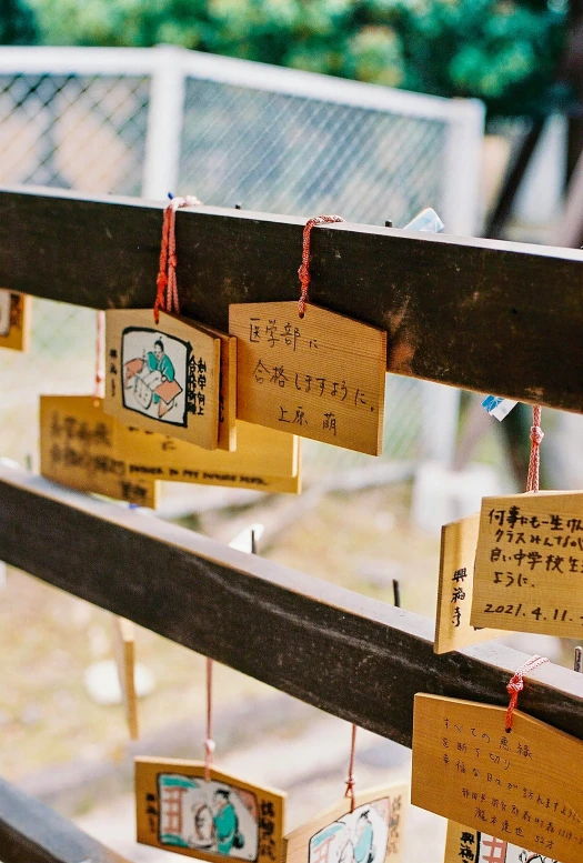 a couple of wooden signs hanging on a fence