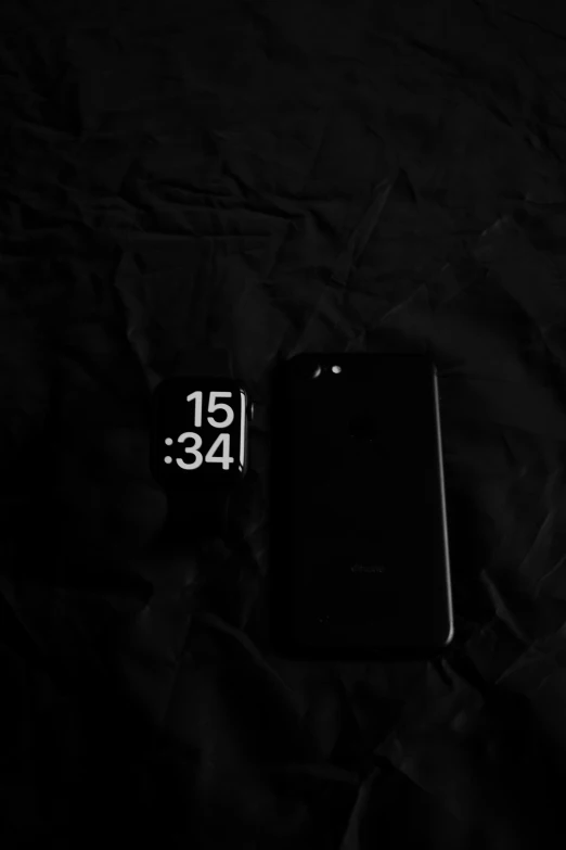 two cell phones are side by side on a bed