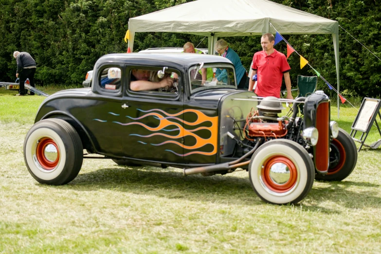 an old  rod car parked in a field