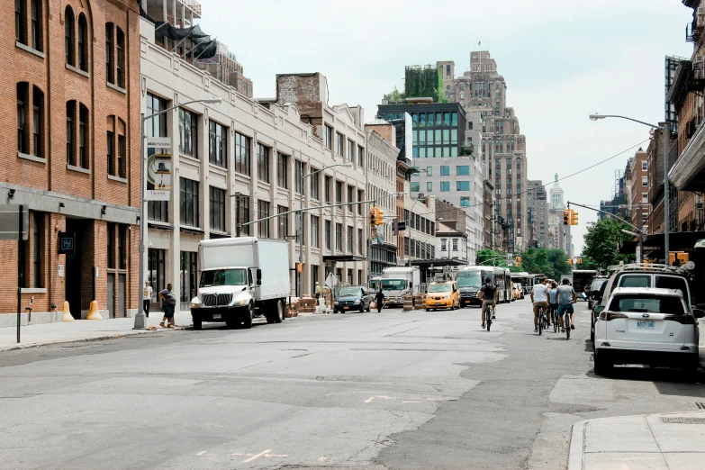 an empty street with parked cars and people walking