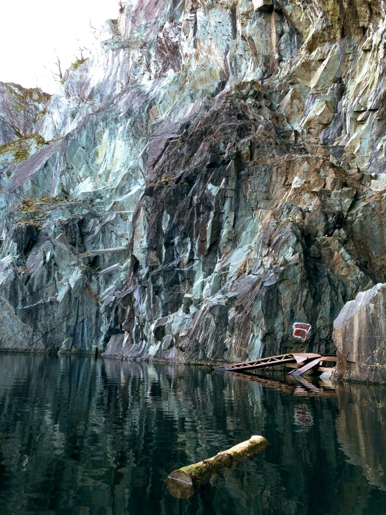 an image of a mountain by water in the day