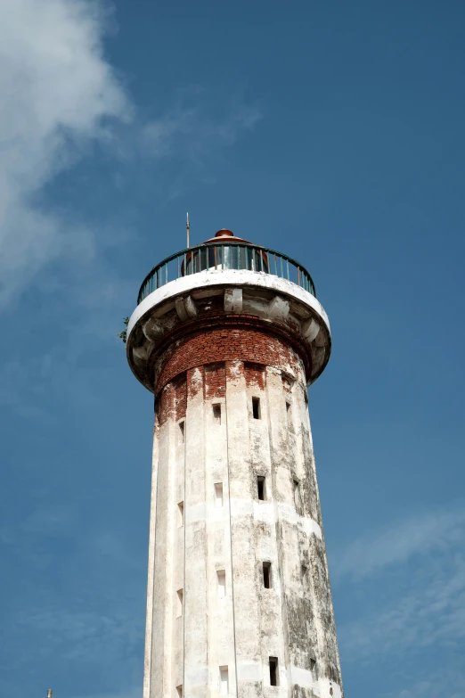 a view looking up at a tall, white lighthouse tower