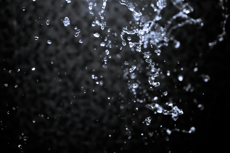 some water flying in the air on a black and white picture