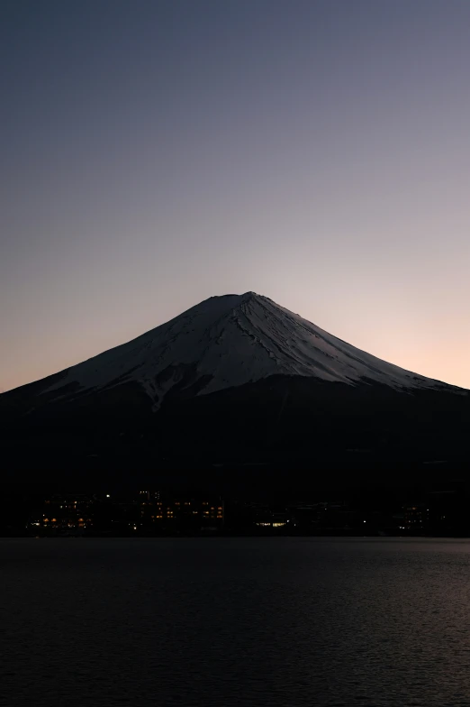 the sky is filled with dark and clouds as the sun rises over the mountain