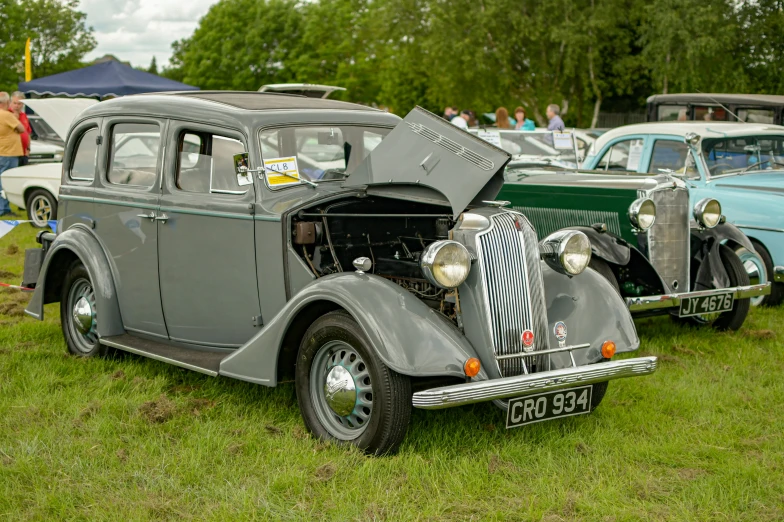 several old cars on display in an antique car show