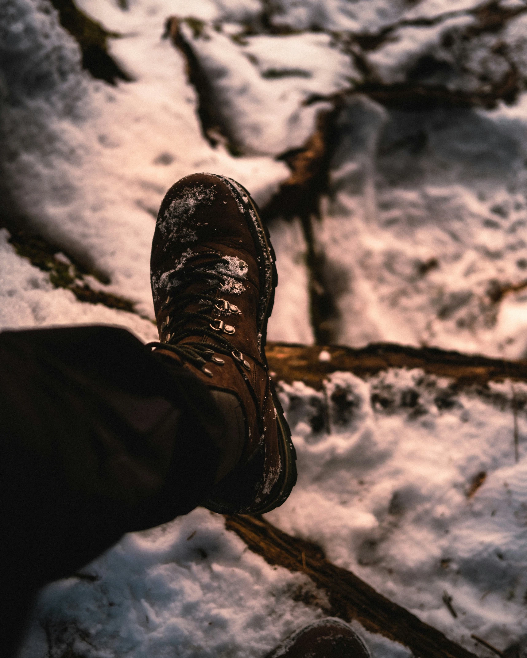 a person is walking in the snow with his foot on a stick