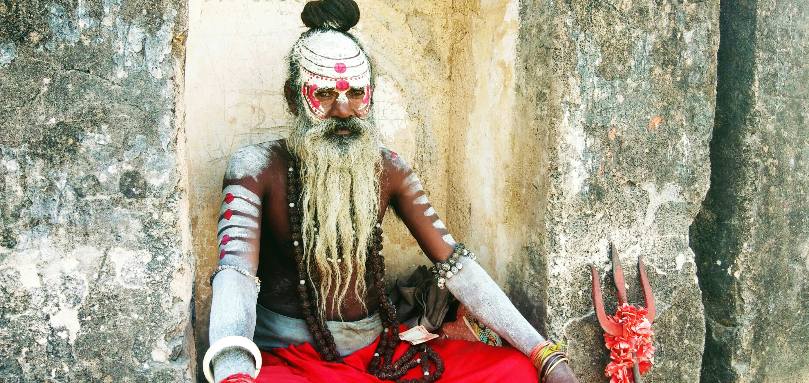 a man with long blonde hair and makeup wearing long hair and some silver arms