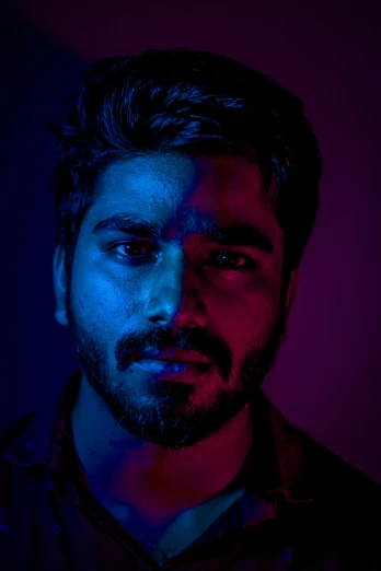 a man with beard and dark blue lighting