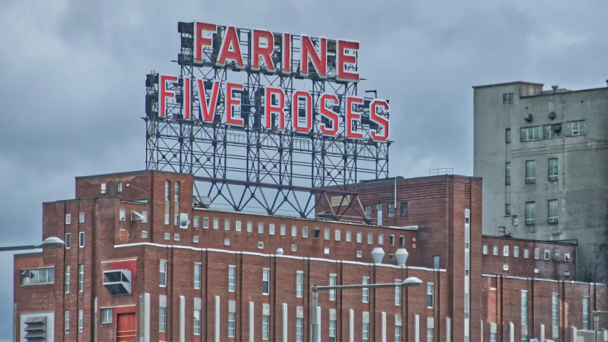 a giant sign atop the building says, caring five roses