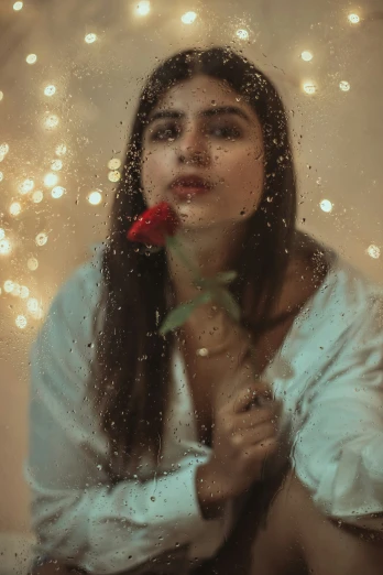 a woman is holding a red rose and making a sad face