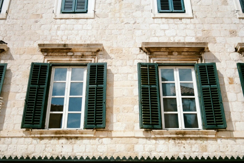 the windows and shutters on the side of a building