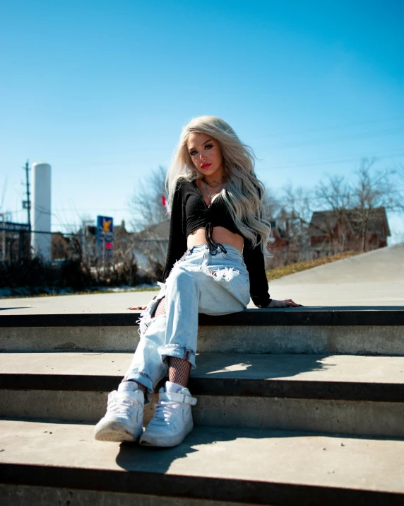 a woman with long hair sitting on some stairs