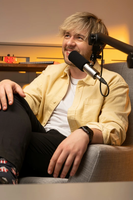 a man sitting in a chair while talking on a microphone