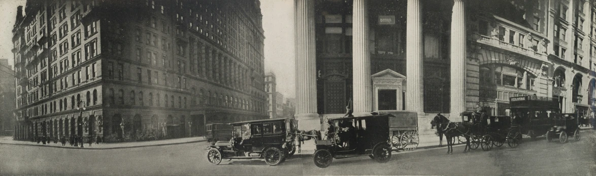 a black and white po shows horse and buggies parked outside of a skyscr