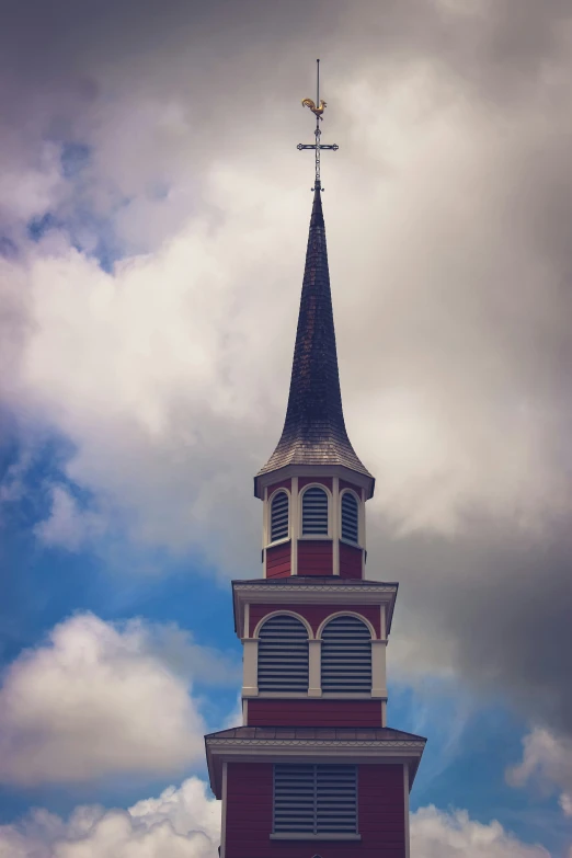 a small tower is surrounded by dark clouds