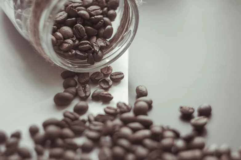 a close up s of coffee beans spilling out of a jar