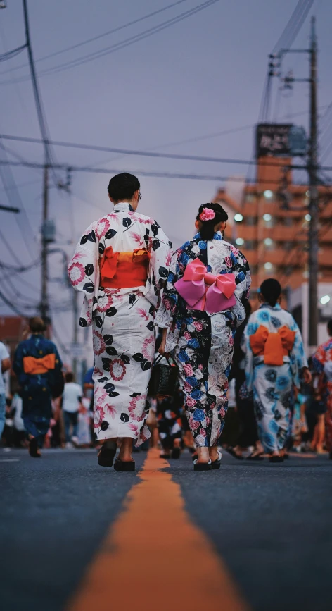 two women walk on a street during the day