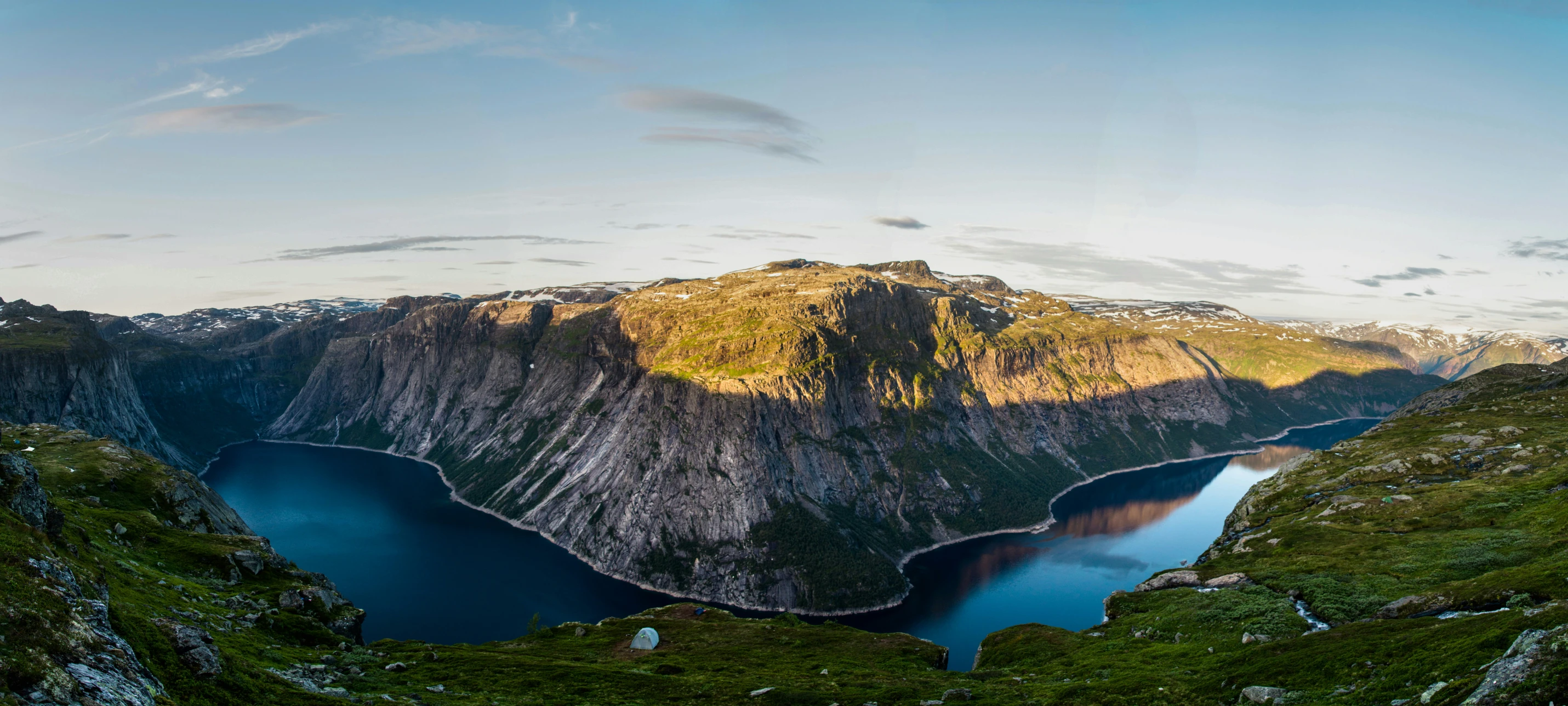 mountain range in the wilderness with blue water and a clear sky