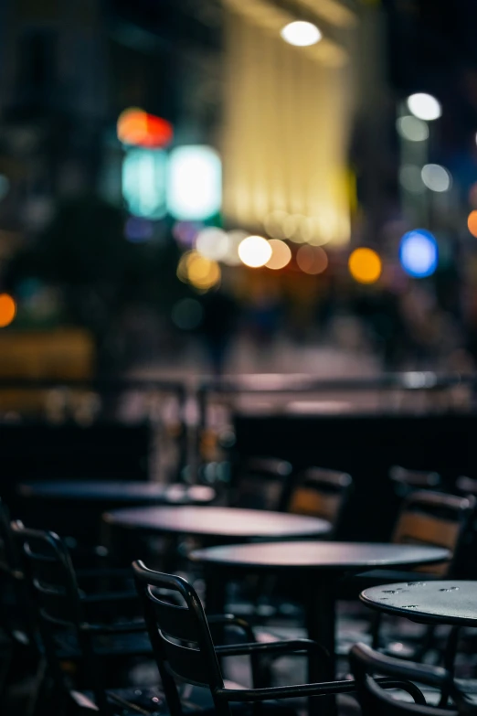 a table with four chairs sitting on the floor and blurry buildings in the background