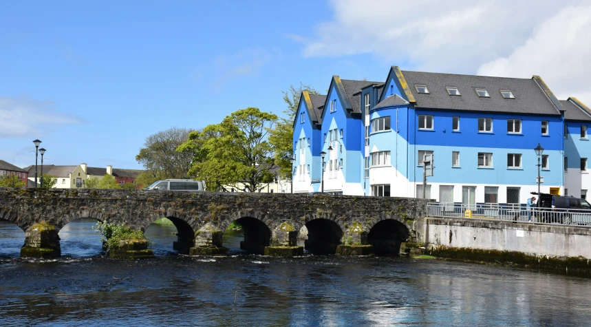 a blue building and a bridge with houses on the other side