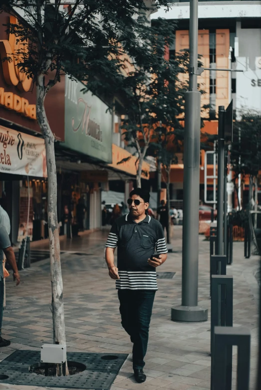 two people walk down the sidewalk near buildings