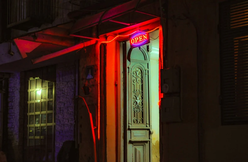 a door with neon signs on it in front of a building