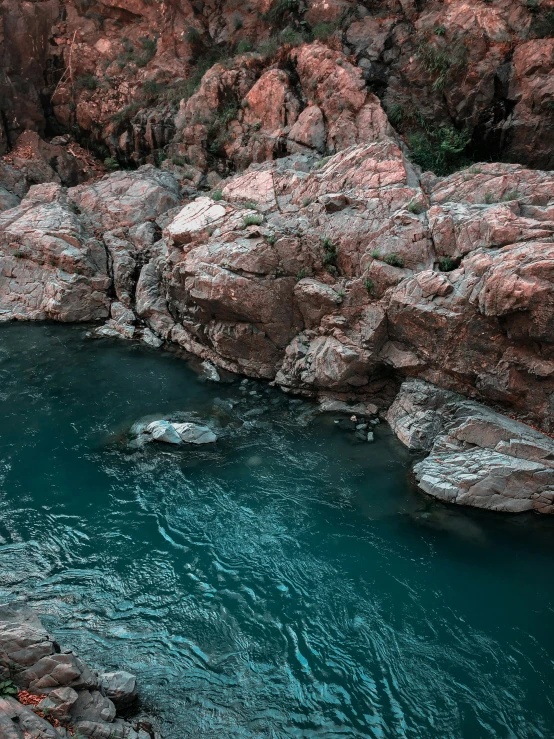 a man standing on rocks next to a river