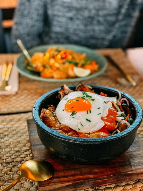 there is a bowl filled with eggs, carrots and other food