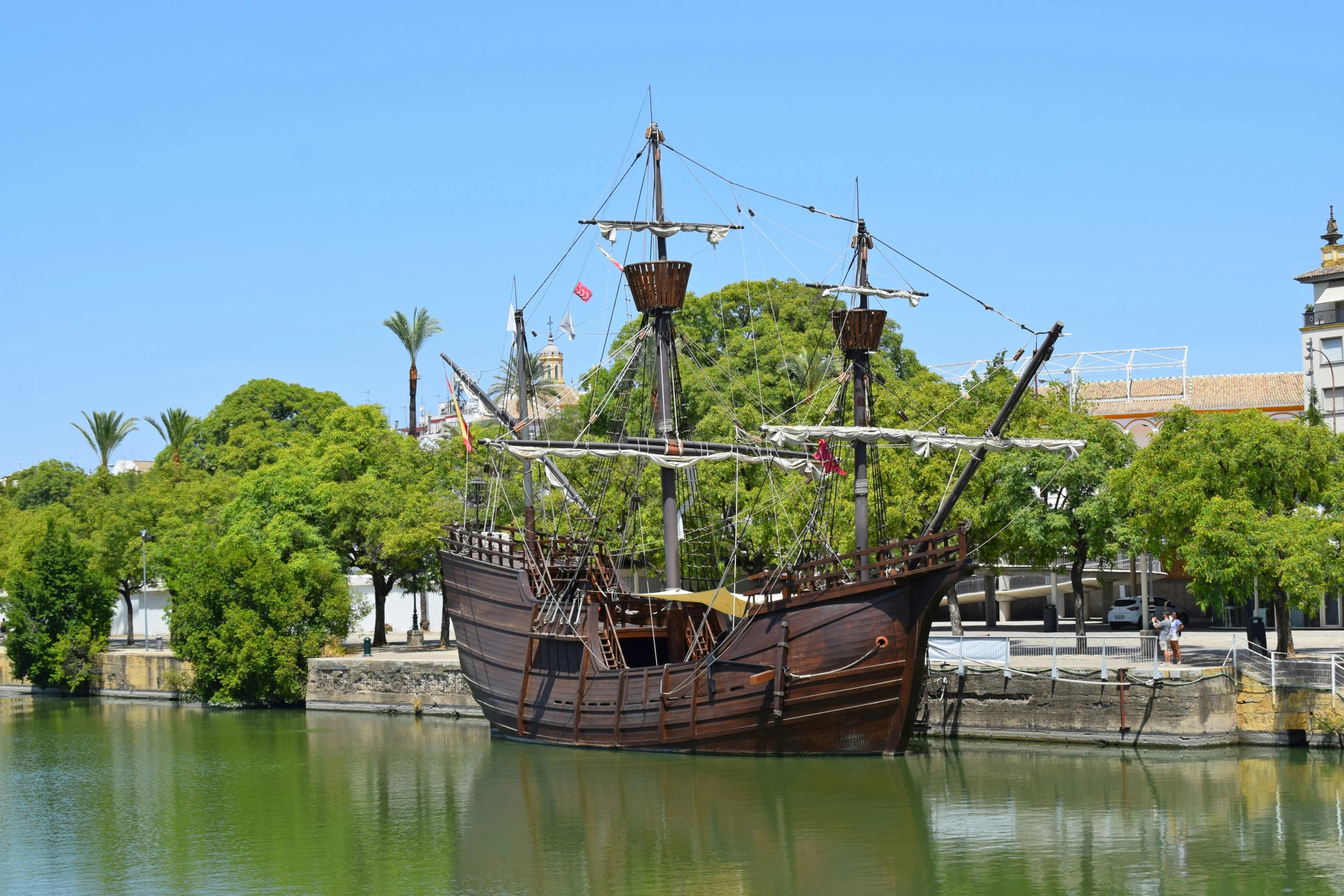 a replica ship sitting in the middle of some water