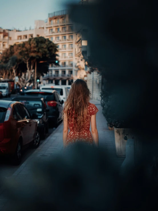 a girl is standing near several cars in a busy street