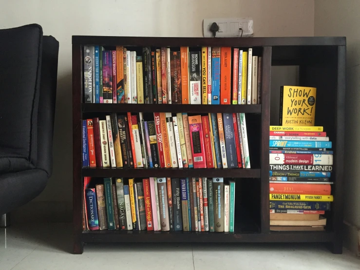 a book shelf with a stack of books sitting on top of it