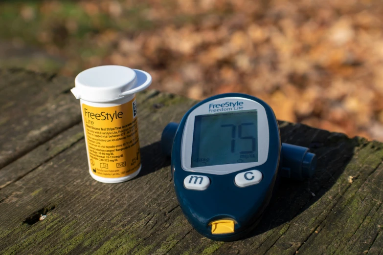 a thermometer and a cup are sitting on a wooden surface