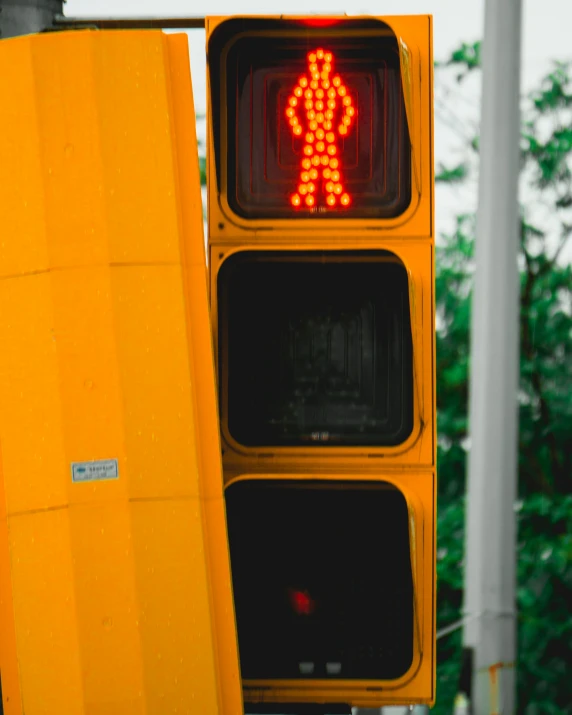 a yellow traffic signal next to a stop light with a walking sign