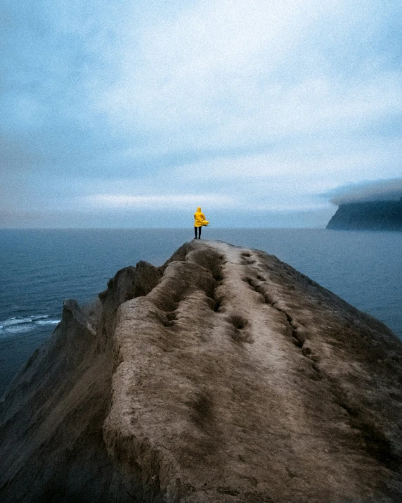 a person on top of a hill next to water