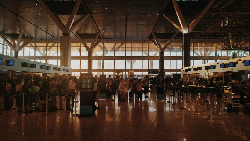 several people are waiting in a lobby next to a train