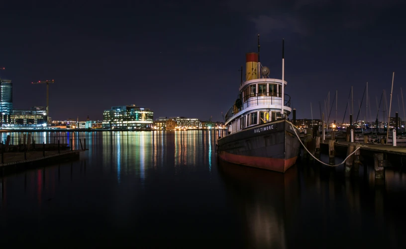 a very pretty boat sitting by some water