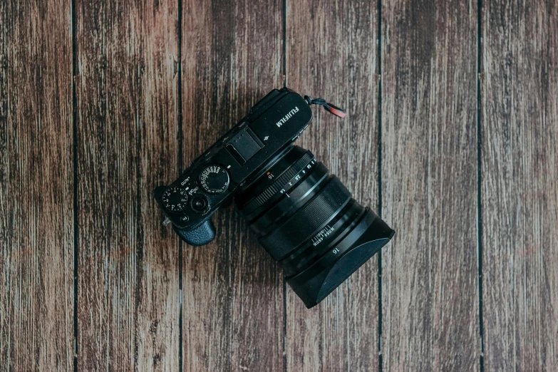 a digital camera lying on top of a wooden table