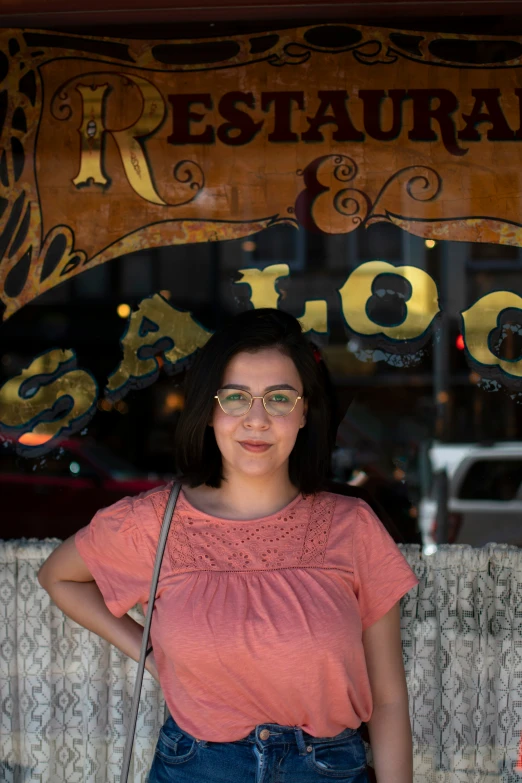 the woman in front of a restaurant has a bag on her shoulder