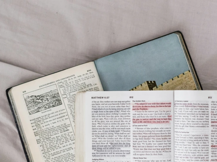 an open book sitting next to an open bible