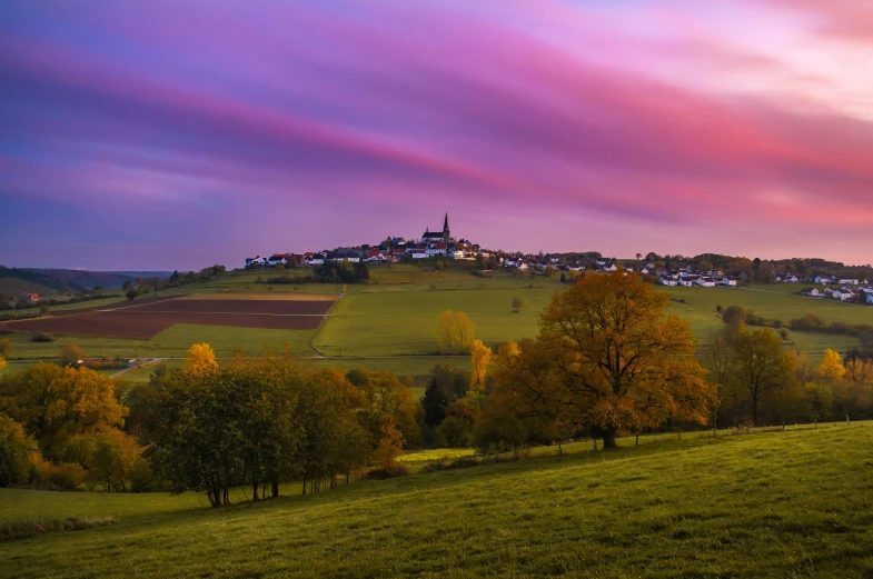 colorful sunset and a pink sky over a village