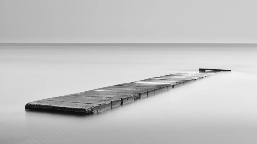 a long pier is partially submerged in the ocean