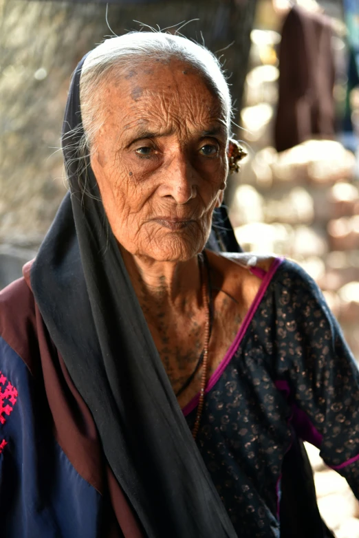 an old woman with white hair and no makeup wearing a black scarf