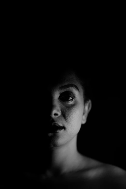 a woman looking to the side, in the dark