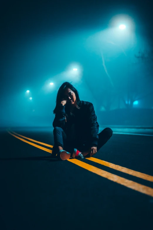 a  crouches on the road in front of traffic lights