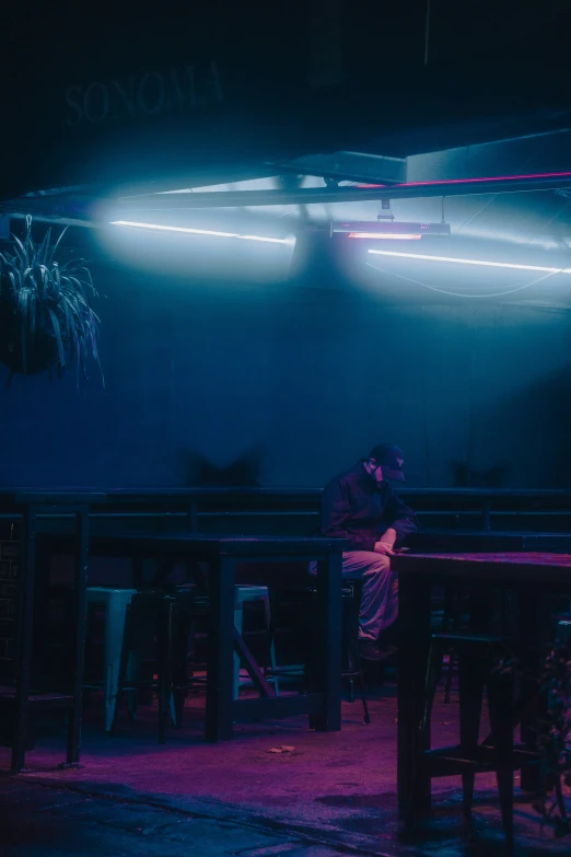 two people sitting at tables in a dark room