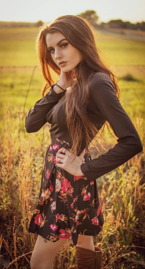 a girl standing in a field near the grass