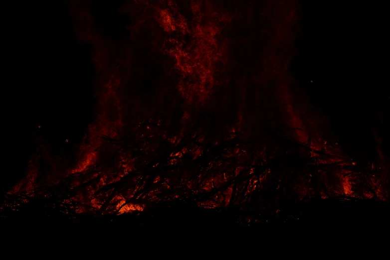 fire with large amount of red lava visible in the dark sky