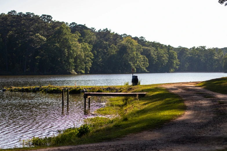 a man is sitting at a bench in the water